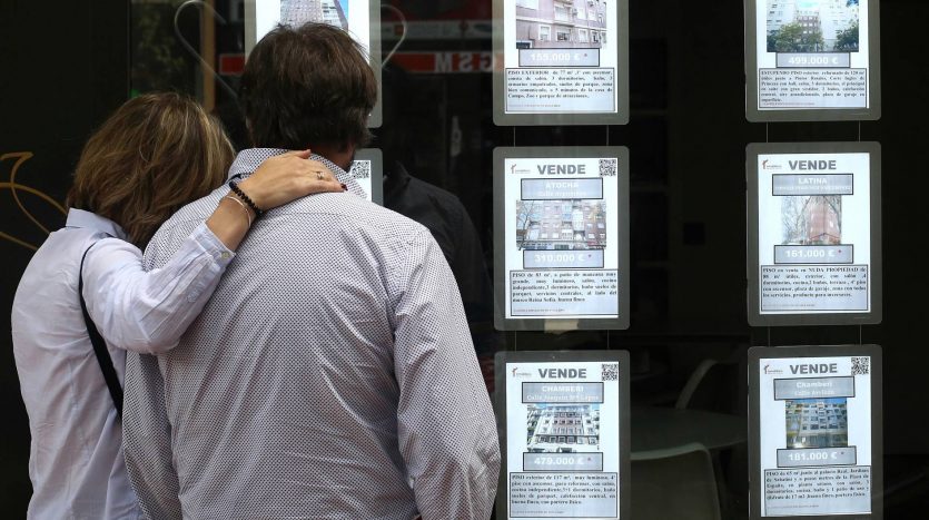 Una pareja observa anuncios de pisos en una inmobiliaria en Madrid (Luis Sevillano)